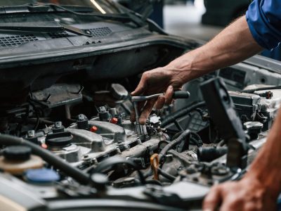 Engine fix. Auto mechanic working in garage. Repair service.